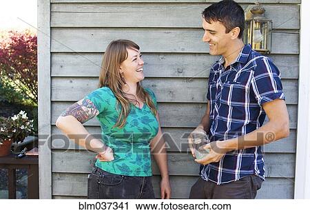 Stock Image - Couple talking near wall. Fotosearch
