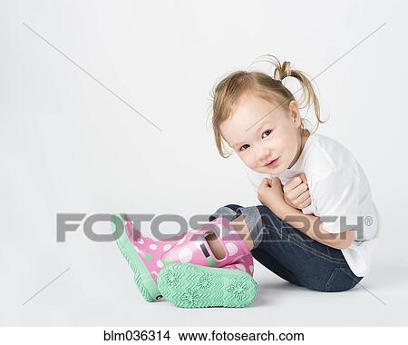 Crouching girl wearing rain boots View Large Photo Image Picture - Crouching girl wearing rain boots. Fotosearch