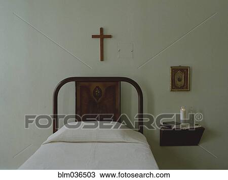Crucifix over bed in simple bedroom View Large Photo Image Stock Image - Crucifix over bed in simple bedroom. Fotosearch