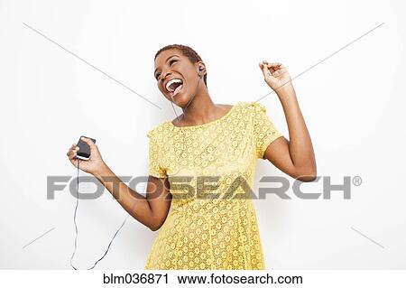 Stock Image - Dancing Black woman dancing to mp3 player. Fotosearch
