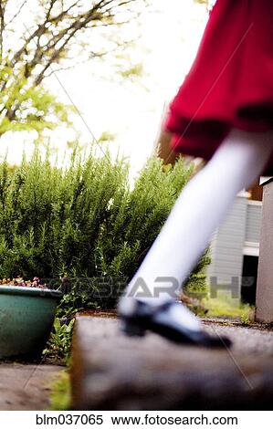 Stock Photography - Defocused view of girl wearing red dress on staircase. Fotosearch