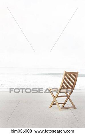 Stock Photo - Empty folding chair on beach. Fotosearch
