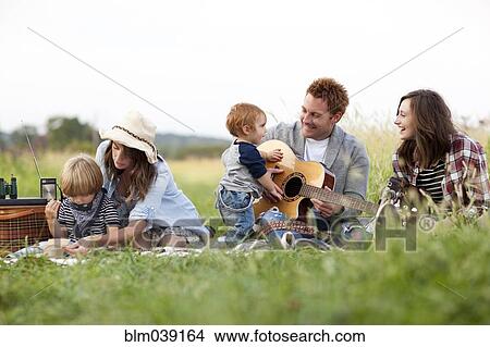 Picture - Family having picnic in rural field. Fotosearch