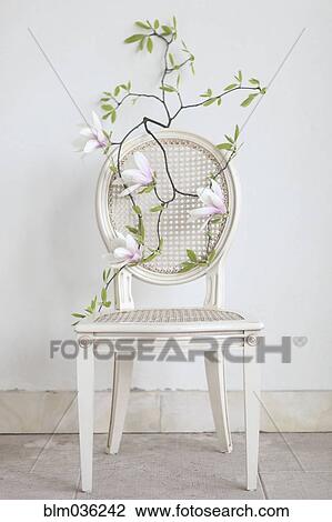 Stock Image - Flowering branch on empty chair. Fotosearch