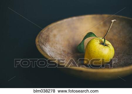 Stock Photo - Fresh lemon and stem in wooden bowl. Fotosearch