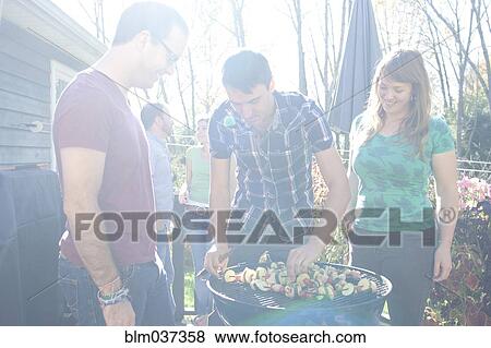 Friends grilling vegetables in backyard View Large Photo Image Stock Photo - Friends grilling vegetables in backyard. Fotosearch