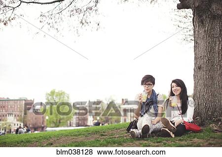 Stock Photo - Friends having drink in urban park. Fotosearch