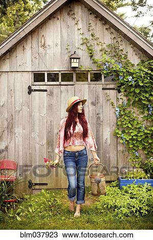 Stock Image - Gardener picking flowers in garden. Fotosearch
