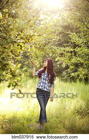 Stock Photography - Girl admiring trees in rural field. Fotosearch