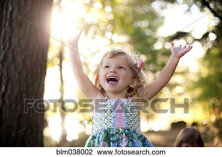 Girl cheering with arms outstretched on forest path View Large Photo Image Stock Image - Girl cheering with arms outstretched on forest path. Fotosearch