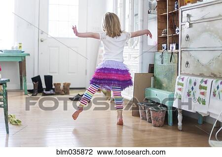 Stock Image - Girl dancing in living room. Fotosearch