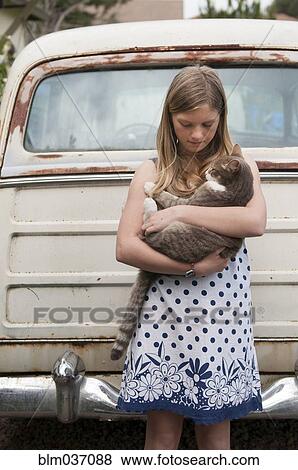 Girl holding cat near vintage car View Large Photo Image Stock Photo - Girl holding cat near vintage car. Fotosearch