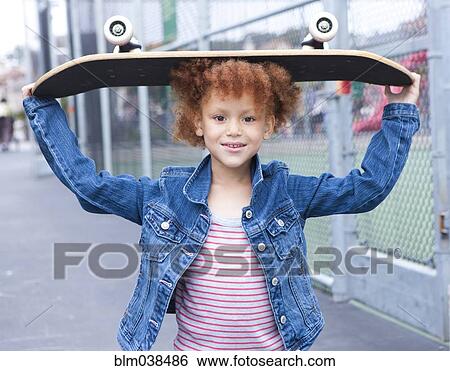 Girl holding skateboard in urban park View Large Photo Image Stock Photograph - Girl holding skateboard in urban park. Fotosearch