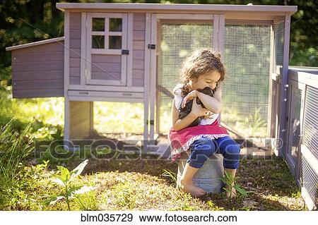 Girl hugging chicken in farm yard View Large Photo Image Stock Photo - Girl hugging chicken in farm yard. Fotosearch