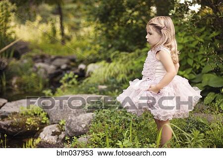 Girl in frilly dress exploring creek View Large Photo Image Stock Image - Girl in frilly dress exploring creek. Fotosearch