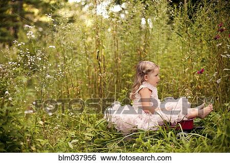 Girl in frilly dress sitting in tall flowers View Large Photo Image Stock Photograph - Girl in frilly dress sitting in tall flowers. Fotosearch