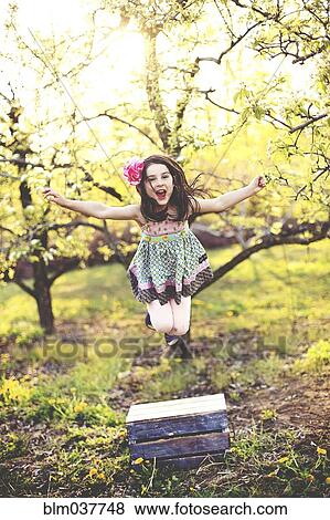 Girl jumping for joy in orchard View Large Photo Image Stock Photo - Girl jumping for joy in orchard. Fotosearch