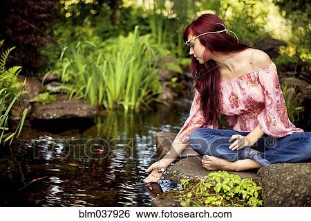 Girl meditating near rural creek View Large Photo Image Stock Photograph - Girl meditating near rural creek. Fotosearch