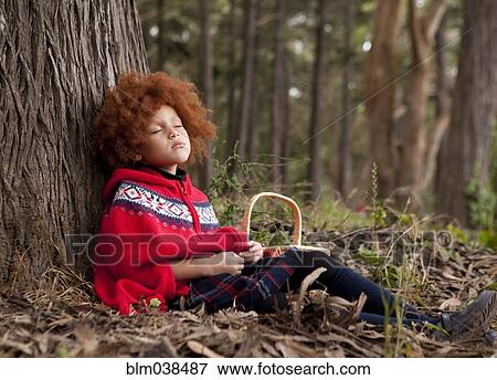 Stock Photo - Girl napping under tree in park. Fotosearch