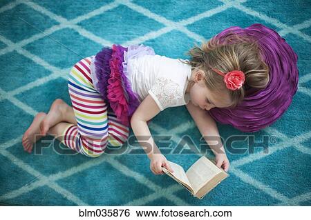 Stock Photograph - Girl reading book on floor. Fotosearch