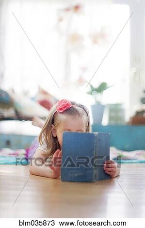 Girl reading book on living room floor View Large Photo Image Stock Image - Girl reading book on living room floor. Fotosearch