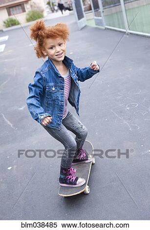 Stock Photography - Girl riding skateboard in urban park. Fotosearch