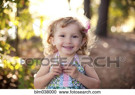 Stock Image - Girl smiling on forest path. Fotosearch