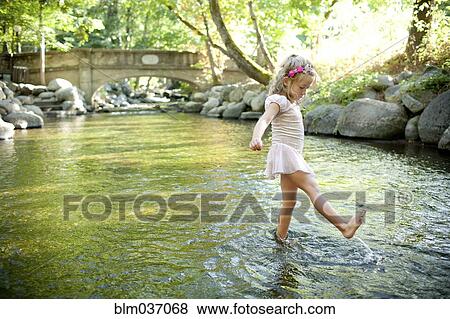 Girl splashing in park river View Large Photo Image Stock Photo - Girl splashing in park river. Fotosearch