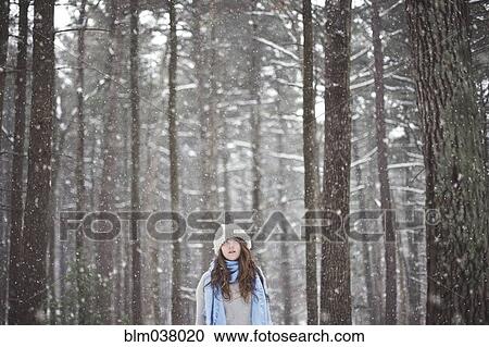 Stock Image - Girl standing in snowy forest. Fotosearch