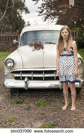 Girl standing near cat on vintage car View Large Photo Image Stock Image - Girl standing near cat on vintage car. Fotosearch
