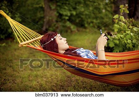 Girl using cell phone and laying in hammock View Large Photo Image Stock Image - Girl using cell phone and laying in hammock. Fotosearch