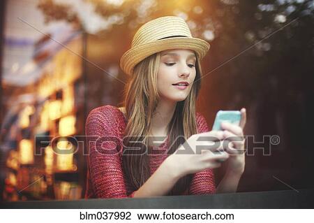 Girl using cell phone near window View Large Photo Image Stock Image - Girl using cell phone near window. Fotosearch