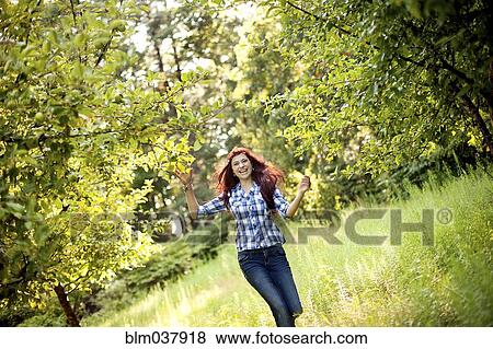 Girl walking in tall grass in rural field View Large Photo Image Stock Photo - Girl walking in tall grass in rural field. Fotosearch