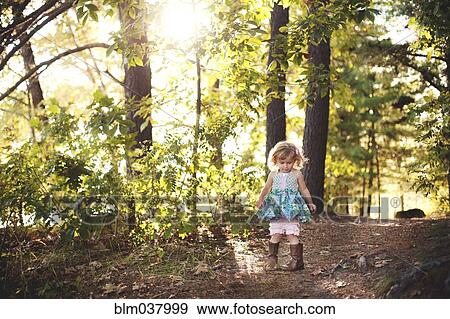 Stock Photo - Girl walking on forest path. Fotosearch