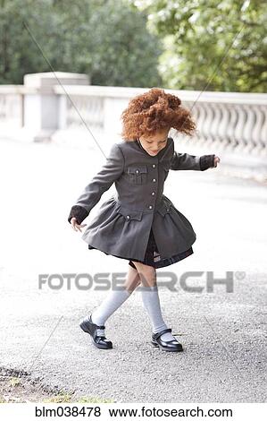 Stock Photo - Girl walking on sidewalk. Fotosearch