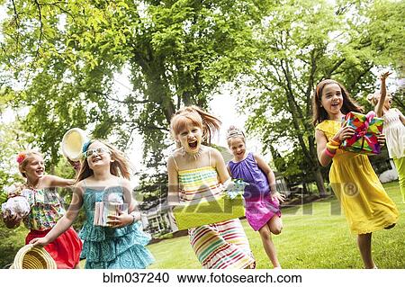Girls carrying gifts at birthday party View Large Photo Image Stock Image - Girls carrying gifts at birthday party. Fotosearch