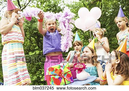 Stock Photography - Girls cheering at birthday party outdoors. Fotosearch