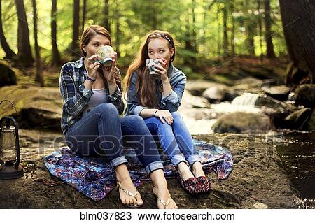 Girls drinking coffee on forest rock View Large Photo Image Stock Image - Girls drinking coffee on forest rock. Fotosearch