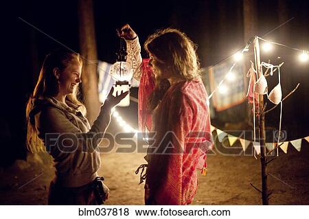 Girls holding lantern at campsite at night View Large Photo Image Stock Photo - Girls holding lantern at campsite at night. Fotosearch