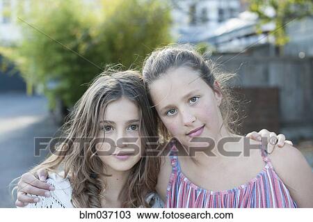 Stock Image - Girls hugging in city. Fotosearch