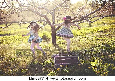 Picture - Girls playing in rural field. Fotosearch