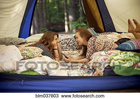 Girls relaxing in camping tent View Large Photo Image Stock Image - Girls relaxing in camping tent. Fotosearch