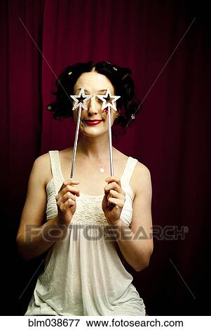 Glamorous woman holding stars over eyes View Large Photo Image Stock Photo - Glamorous woman holding stars over eyes. Fotosearch