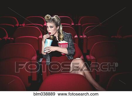 Glamorous woman in vintage clothing watching movie in theater View Large Photo Image Stock Photo - Glamorous woman in vintage clothing watching movie in theater. Fotosearch