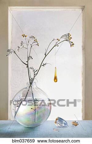 Stock Photo - Glass ornament hanging from plants in glass vase. Fotosearch