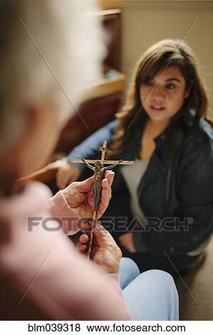 Stock Photo - Granddaughter and grandmother praying with crucifix. Fotosearch