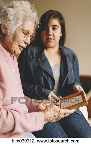Grandmother and granddaughter admiring old photograph View Large Photo Image Stock Image - Grandmother and granddaughter admiring old photograph. Fotosearch