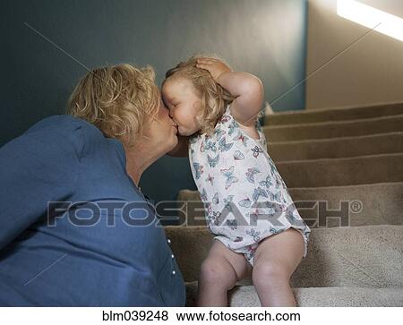 Stock Photo - Grandmother and granddaughter kissing on staircase. Fotosearch
