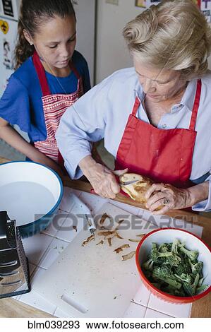 Grandmother and granddaughter peeling potato in kitchen View Large Photo Image Stock Image - Grandmother and granddaughter peeling potato in kitchen. Fotosearch