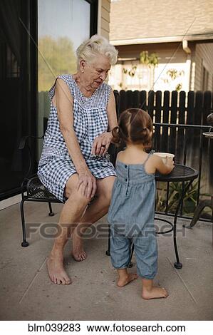 Grandmother and granddaughter playing on patio View Large Photo Image Stock Image - Grandmother and granddaughter playing on patio. Fotosearch